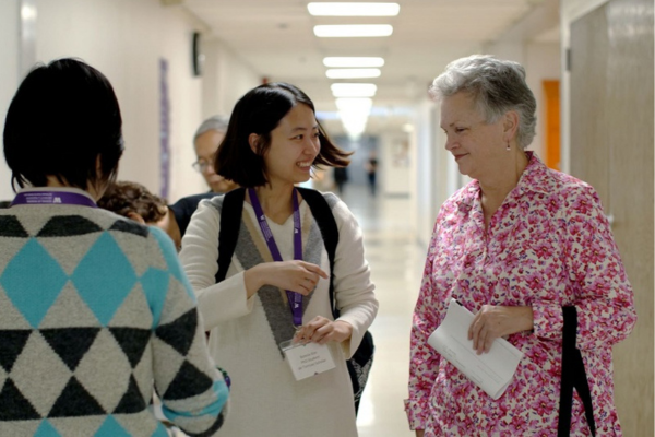 student and faculty talking in a hallway